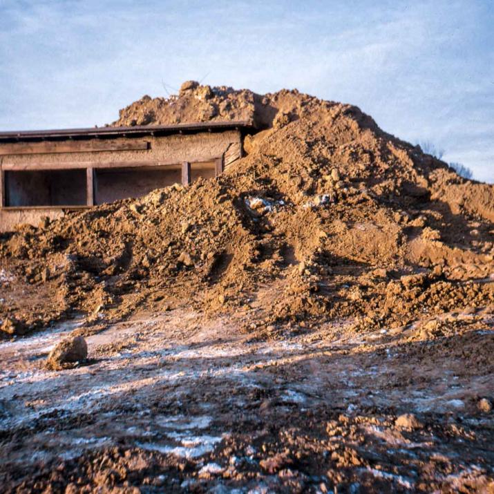 A 1970 work by Robert Smithson. Smithson piled earth atop an old woodshed on the campus of Kent State University until the center beam cracked.