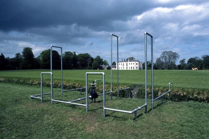 a structure built of galvanized steel pipes built in a grassy field