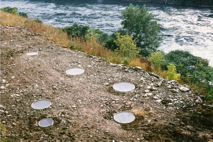 six circular pools of water embedded along the shoreline of a river
