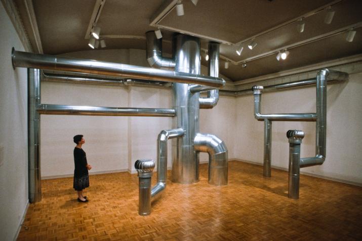 a room full of large metal ventilation pipes that curve around the space.