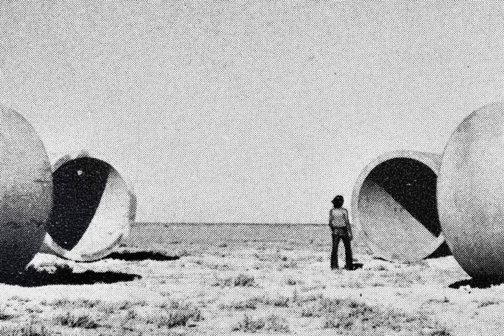 black and white, four sun tunnels with a person standing looking through one