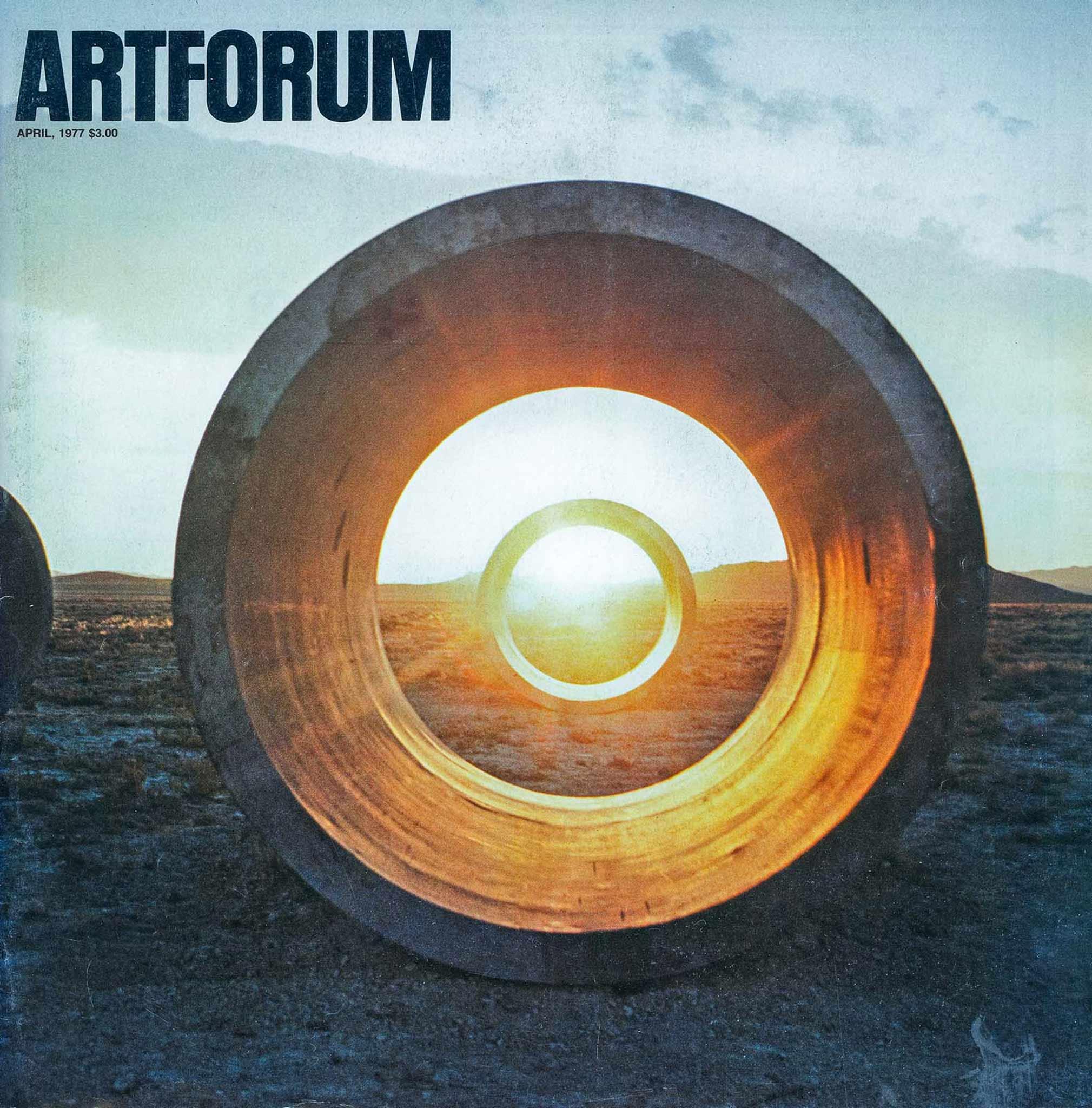 Magazine cover with the artforum logo in black in the upper left corner.  Cover image of two large concrete tunnels in line in the Utah desert, with the sun setting behind the second tunnel.
