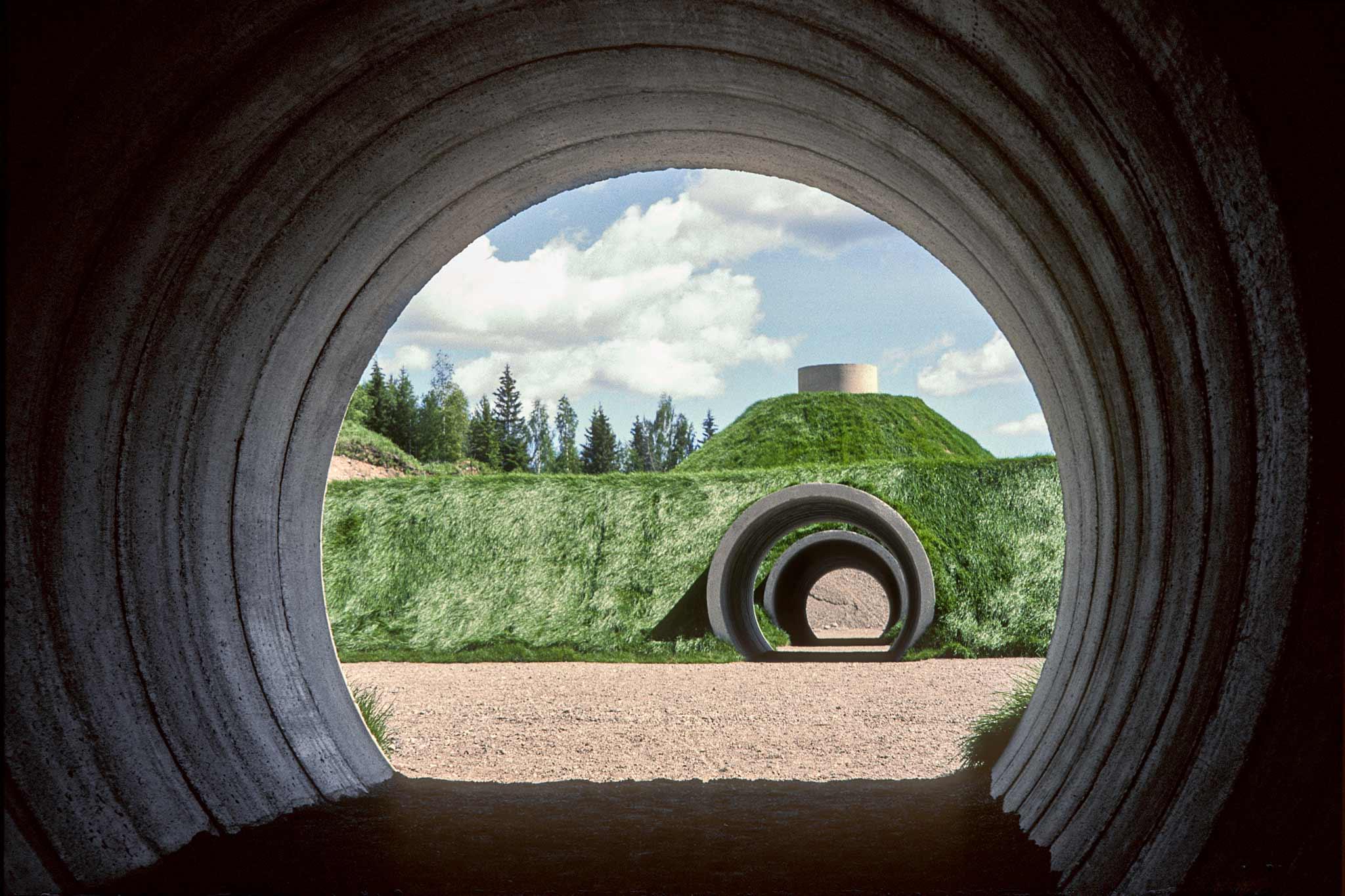 Interior view of a circular tunnel looking out onto a mound of earth with tunnels cutting through it.