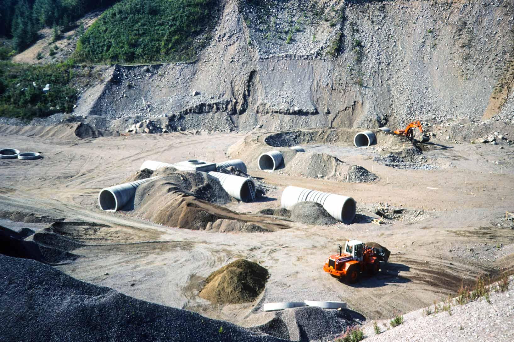 Construction image of concrete tunnels and earth being moved into place
