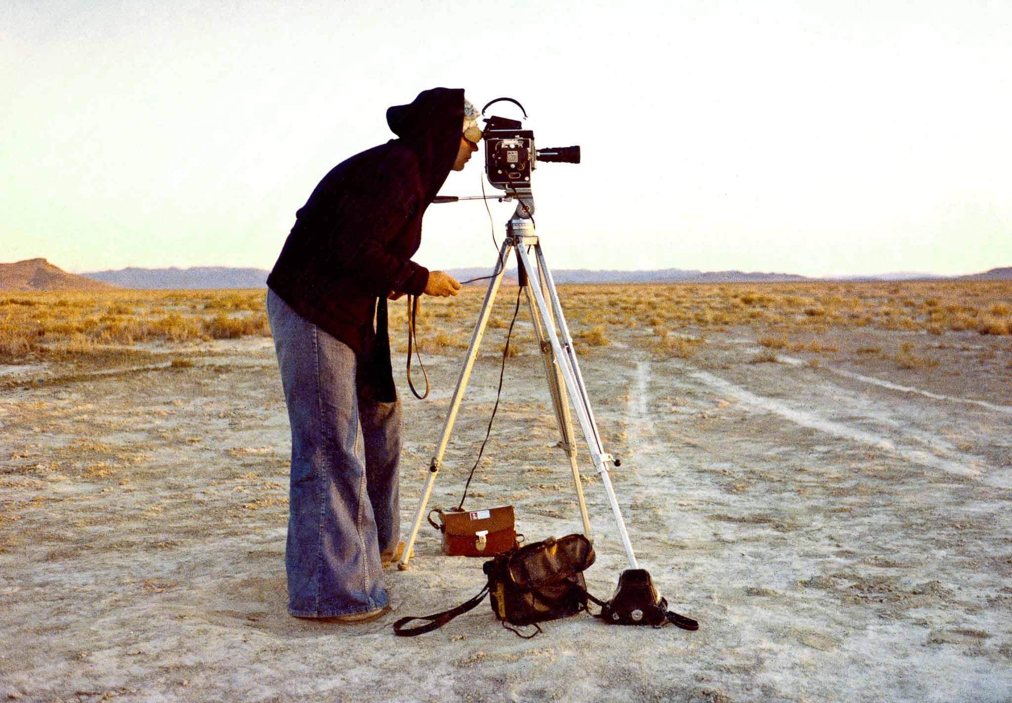 Nancy Holt filming the Spiral Jetty with her Bolex 16 millimeter film camera.