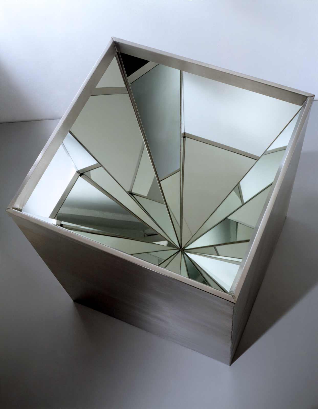 A 28 x 28 inch metal box that is open on the top and lined with four triangular mirrors at meet at their apex.