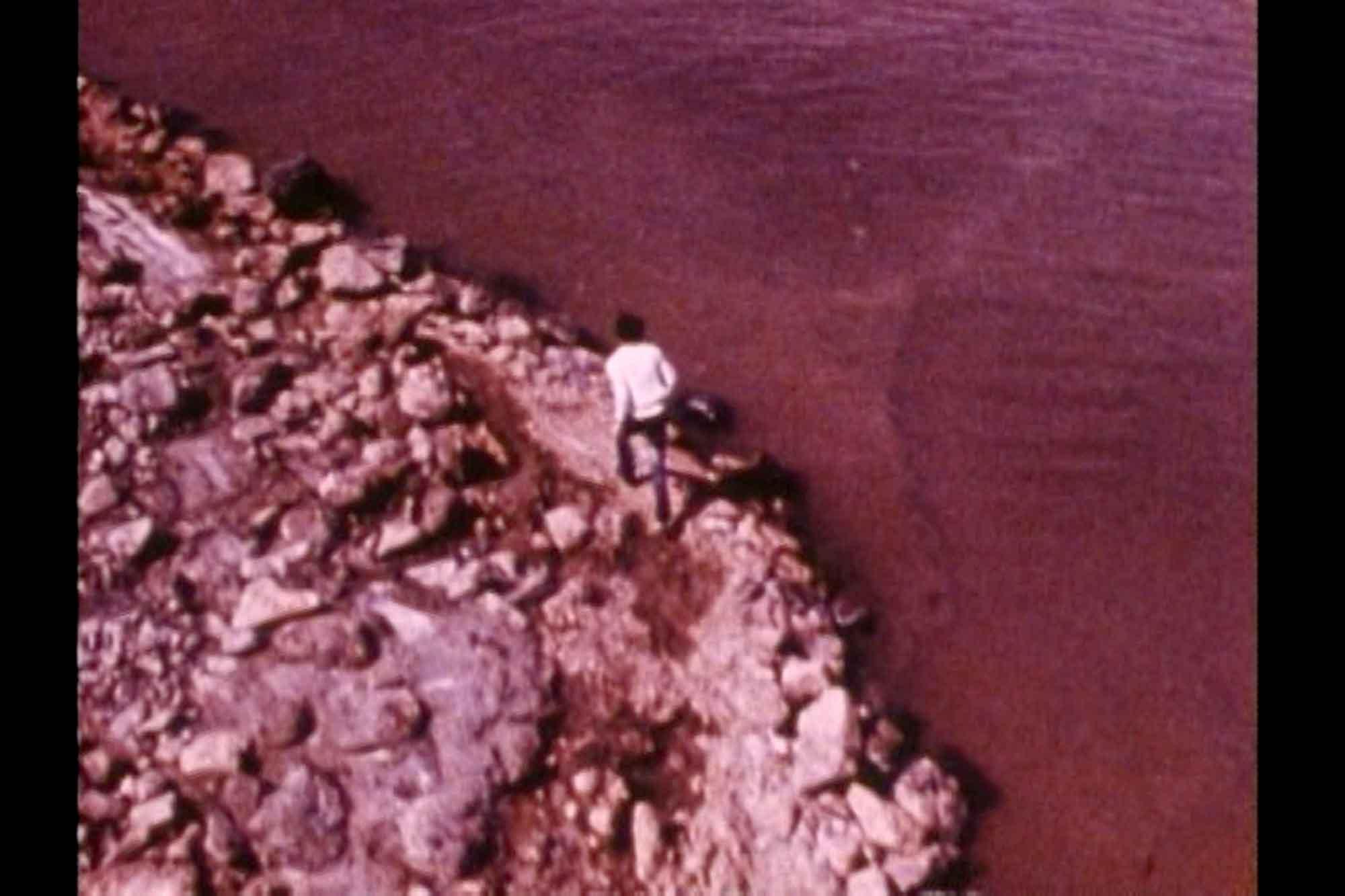A still from the film Spiral Jetty shot from a helicopter showing Smithson running on the jetty.