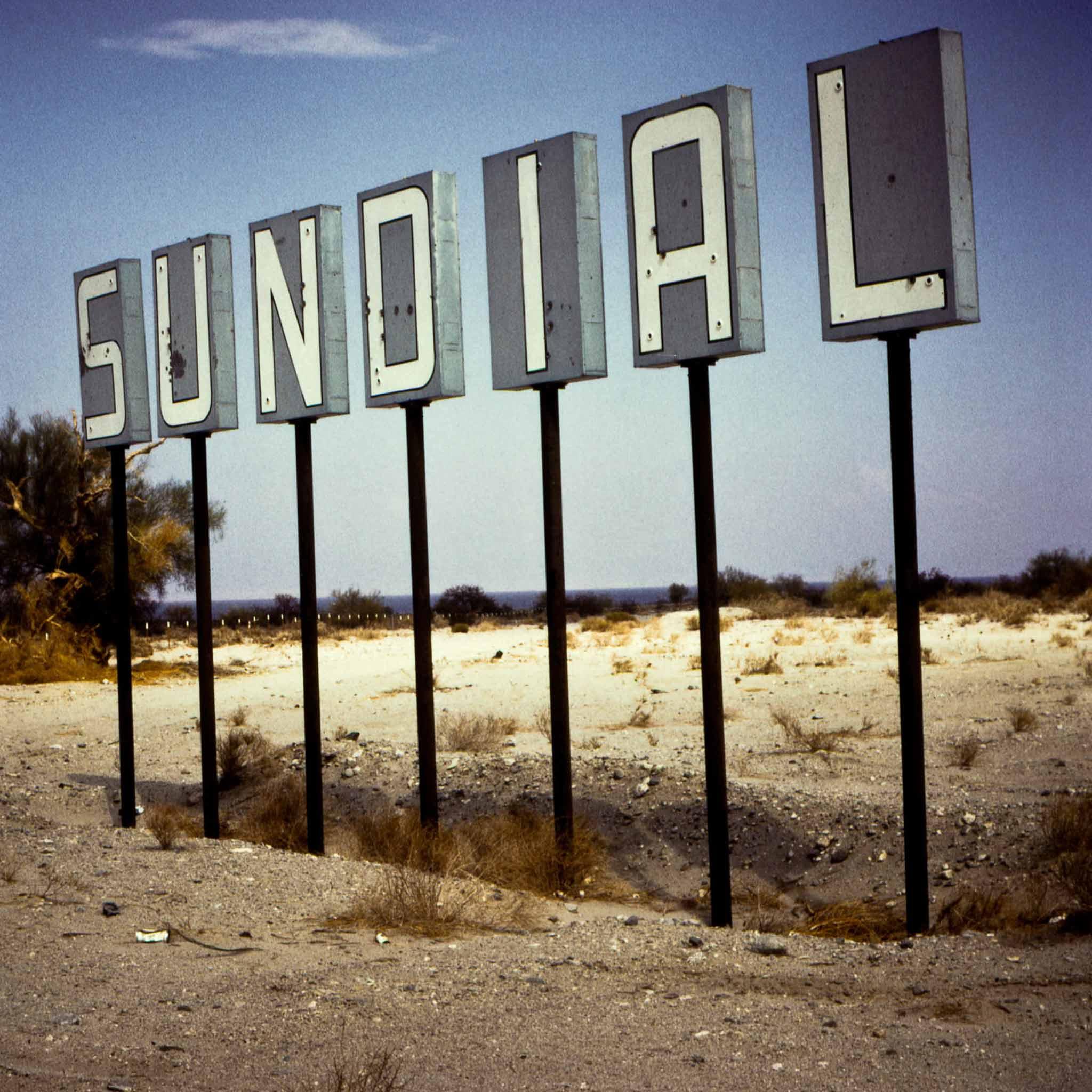 a sign in the desert that says "Sundial"