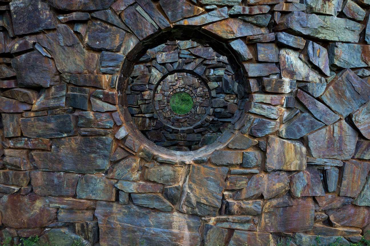 Stone walls receding in space with concentric circular holes in the center.  