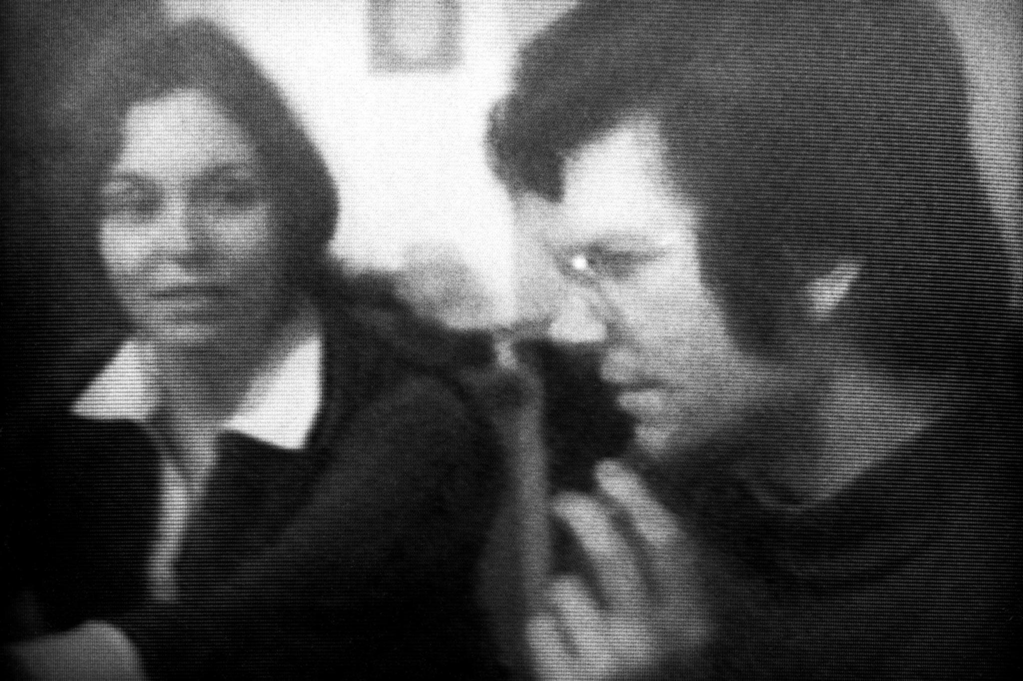 black and white film image of a close up of a man and woman in conversation.