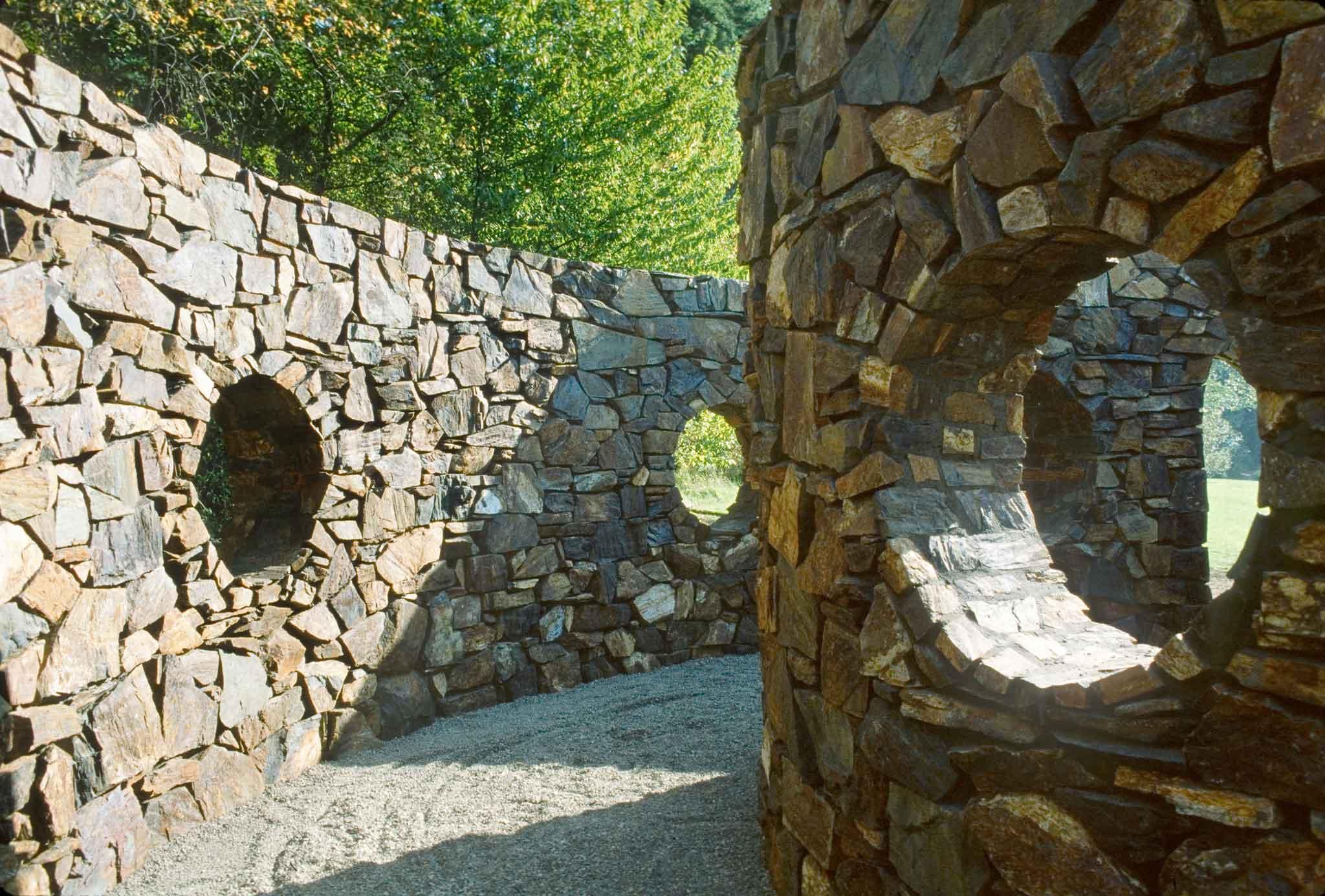 Two curved stone walls with circular openings.