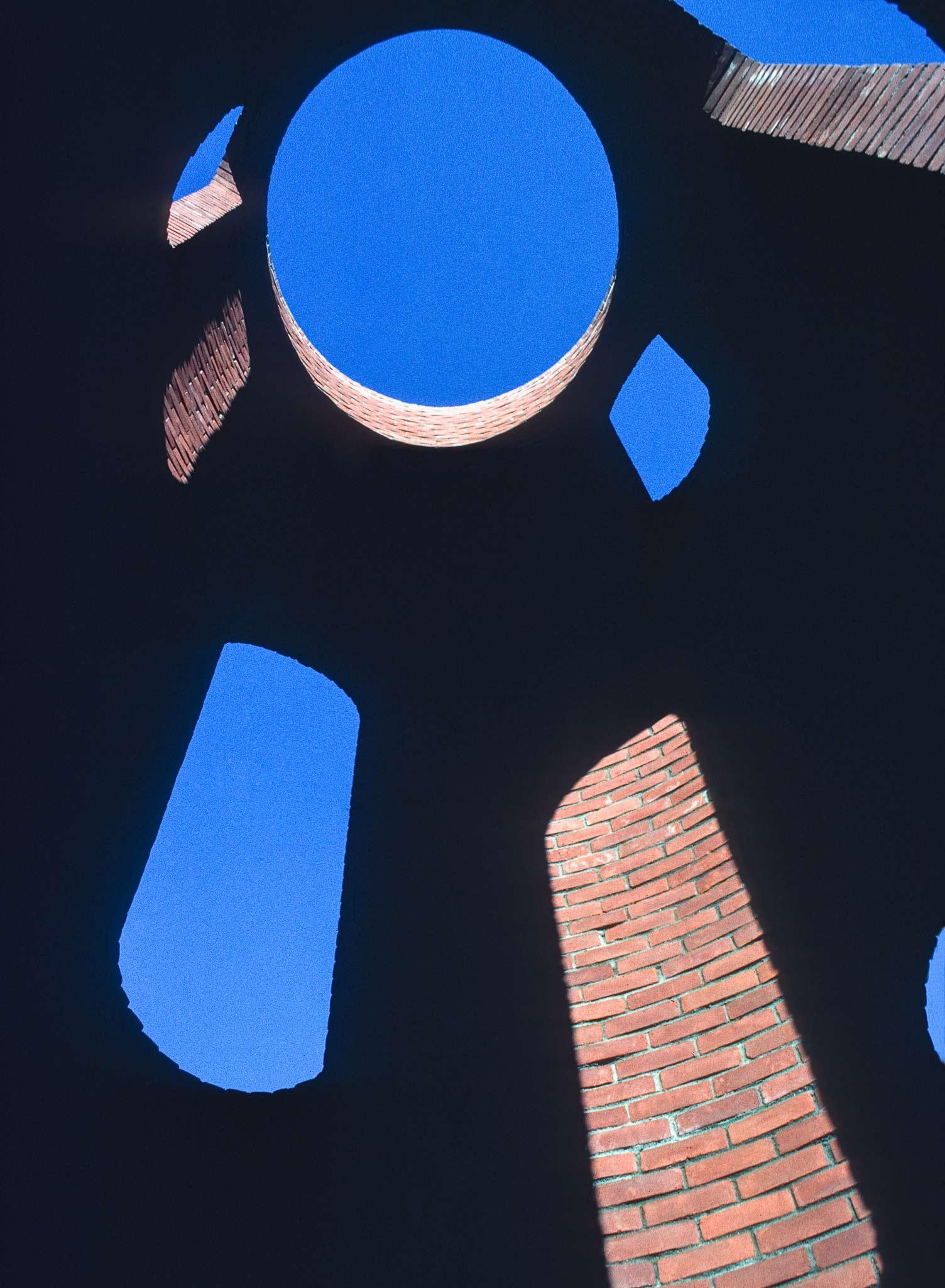 Interior view of a tall circular brick structure with a circular oculus at the top