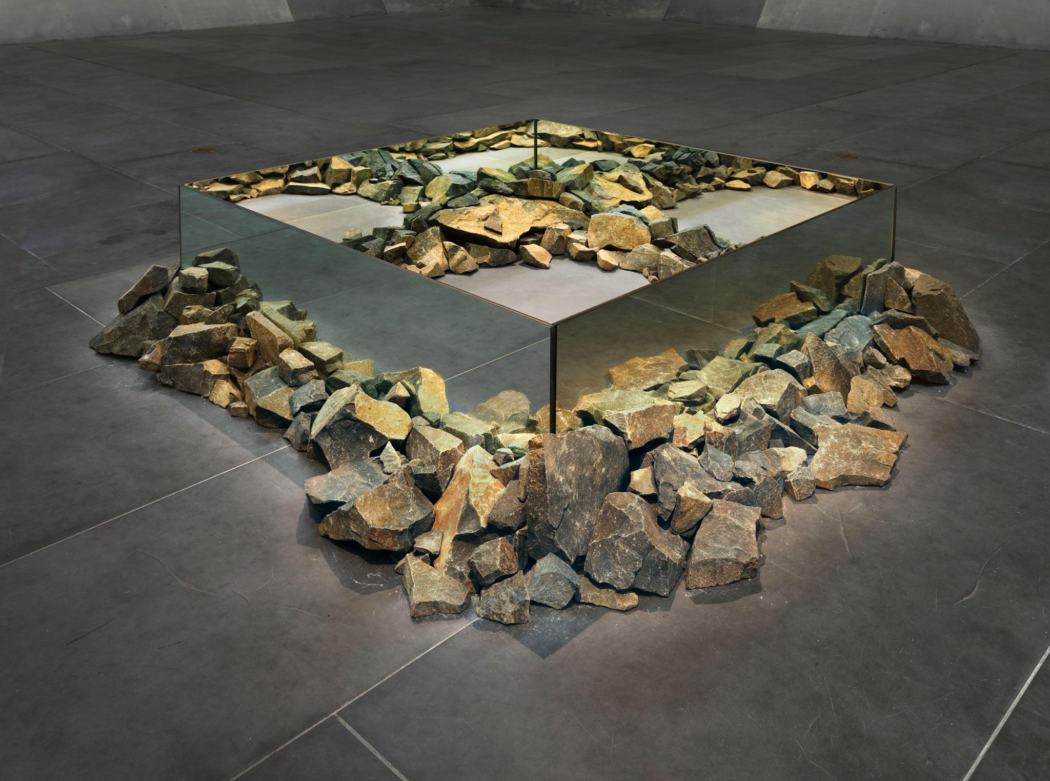 sculpture made using rocks and mirrors placed on the ground in a square shape