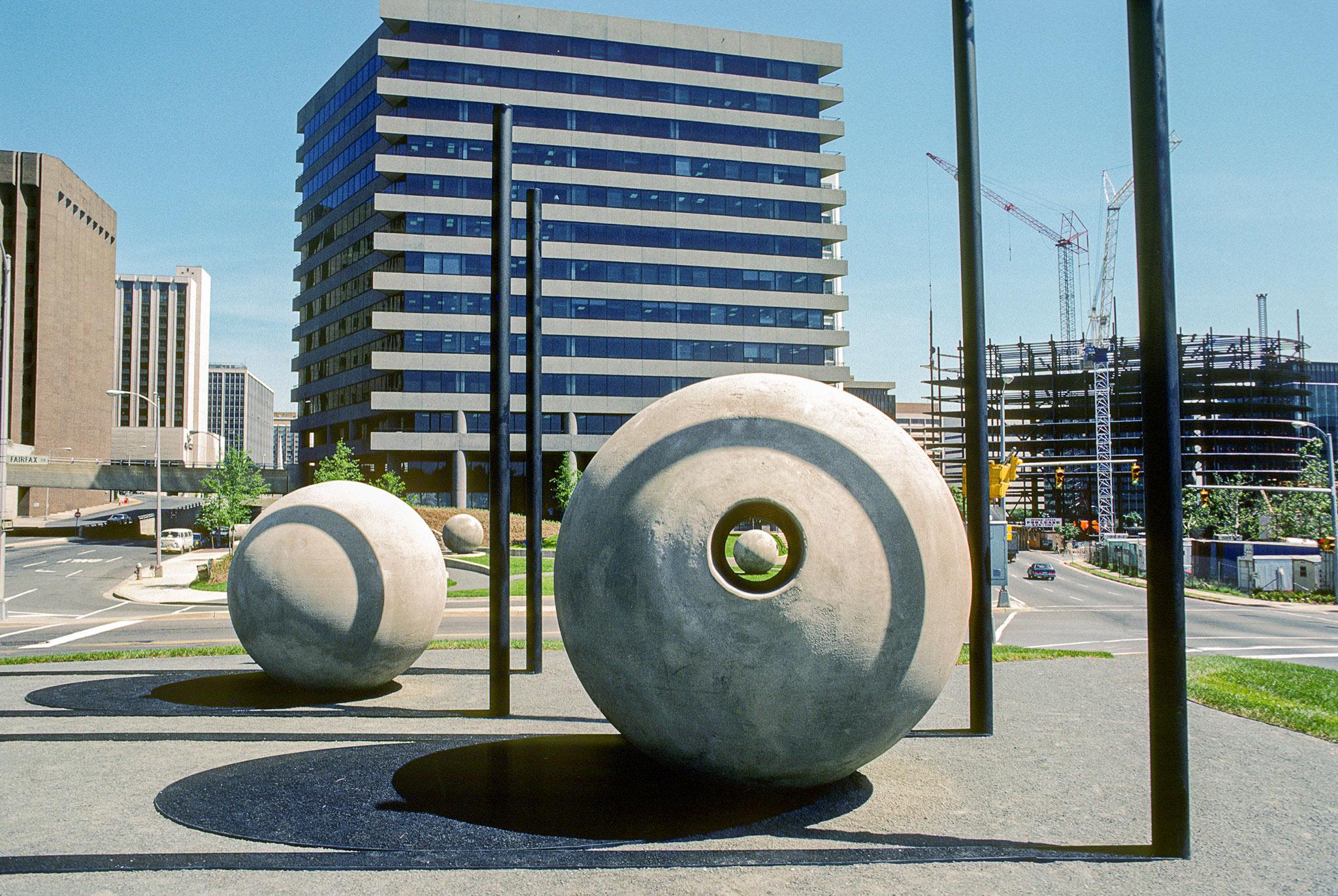large concrete spheres in a park with a small tunnel through one of the spheres