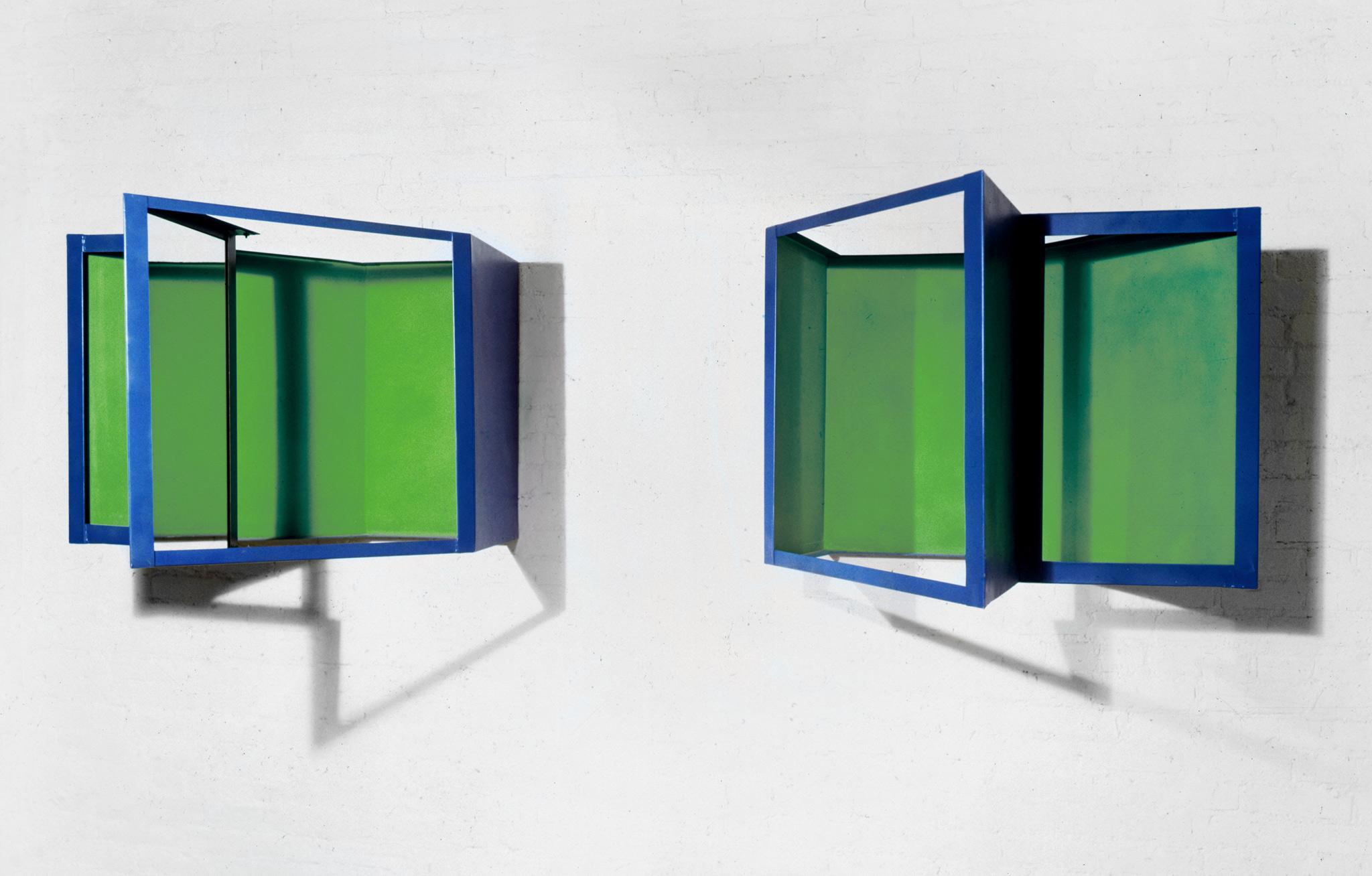 Two blue and green geometric sculptures hanging on wall